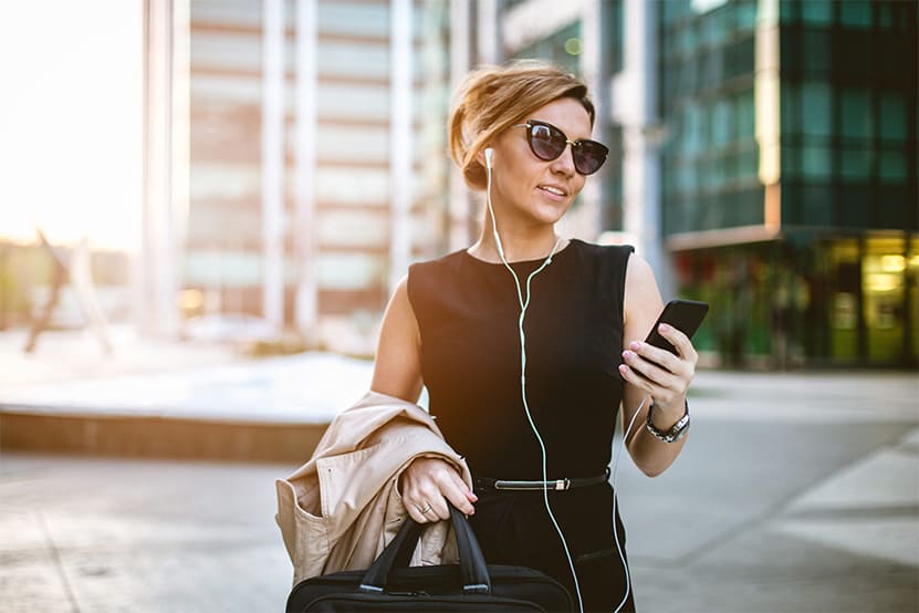 Woman looking at her phone while wearing headphones